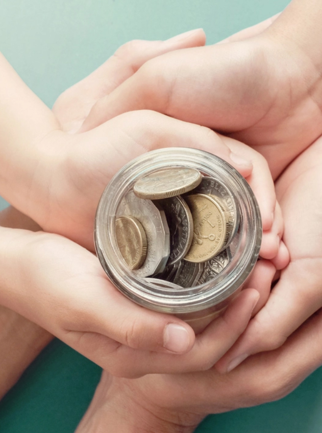 Hands holding jar of money